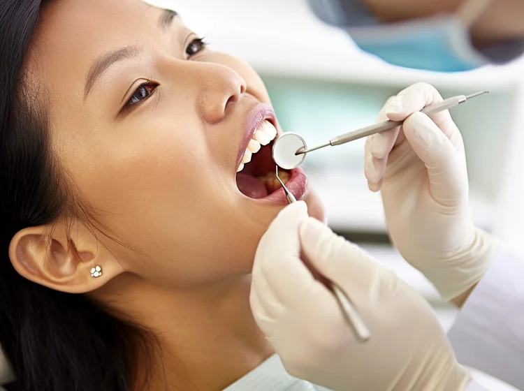 Dentist assessing the dental condition of a female patient during an initial consultation for teeth veneers treatment.