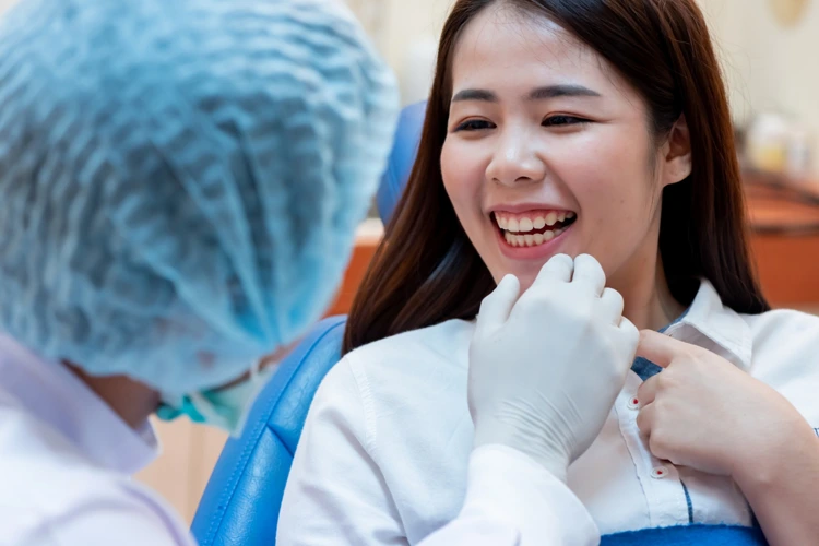 Female patient showing her teeth to the dentist for general dental inspection.
