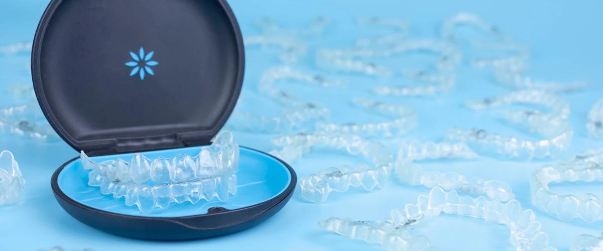 Invisalign braces in a case surrounded by many sets of Invisalign.
