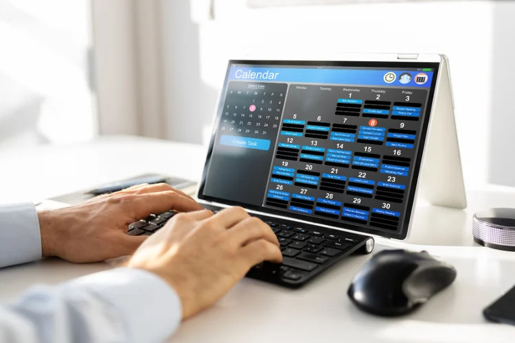 Person using a tablet to schedule a dental appointment on a digital calendar at a conveniently located dental clinic in Singapore.